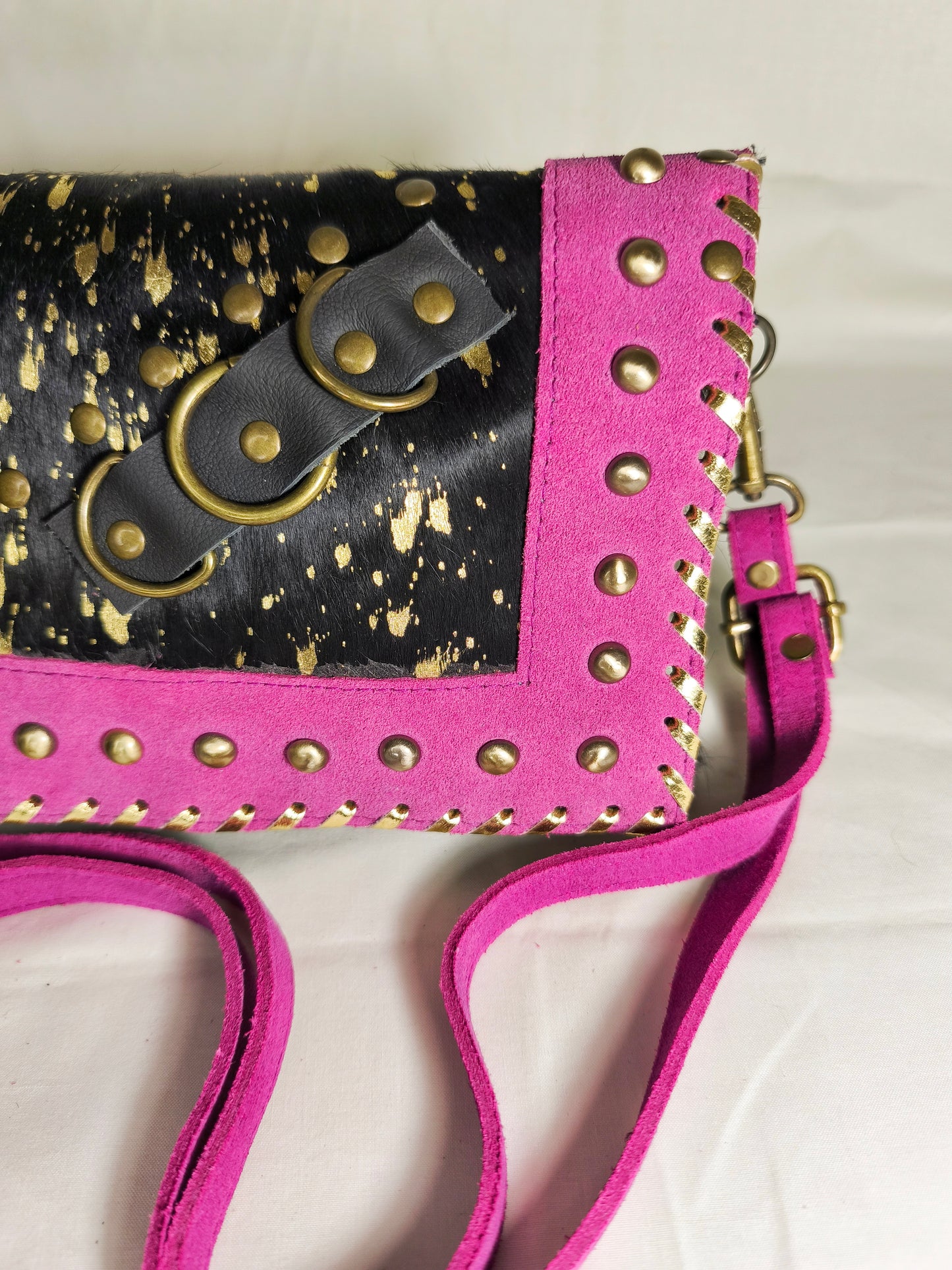 Bolso artesanal en piel con salpicaduras doradas y marco fucsia