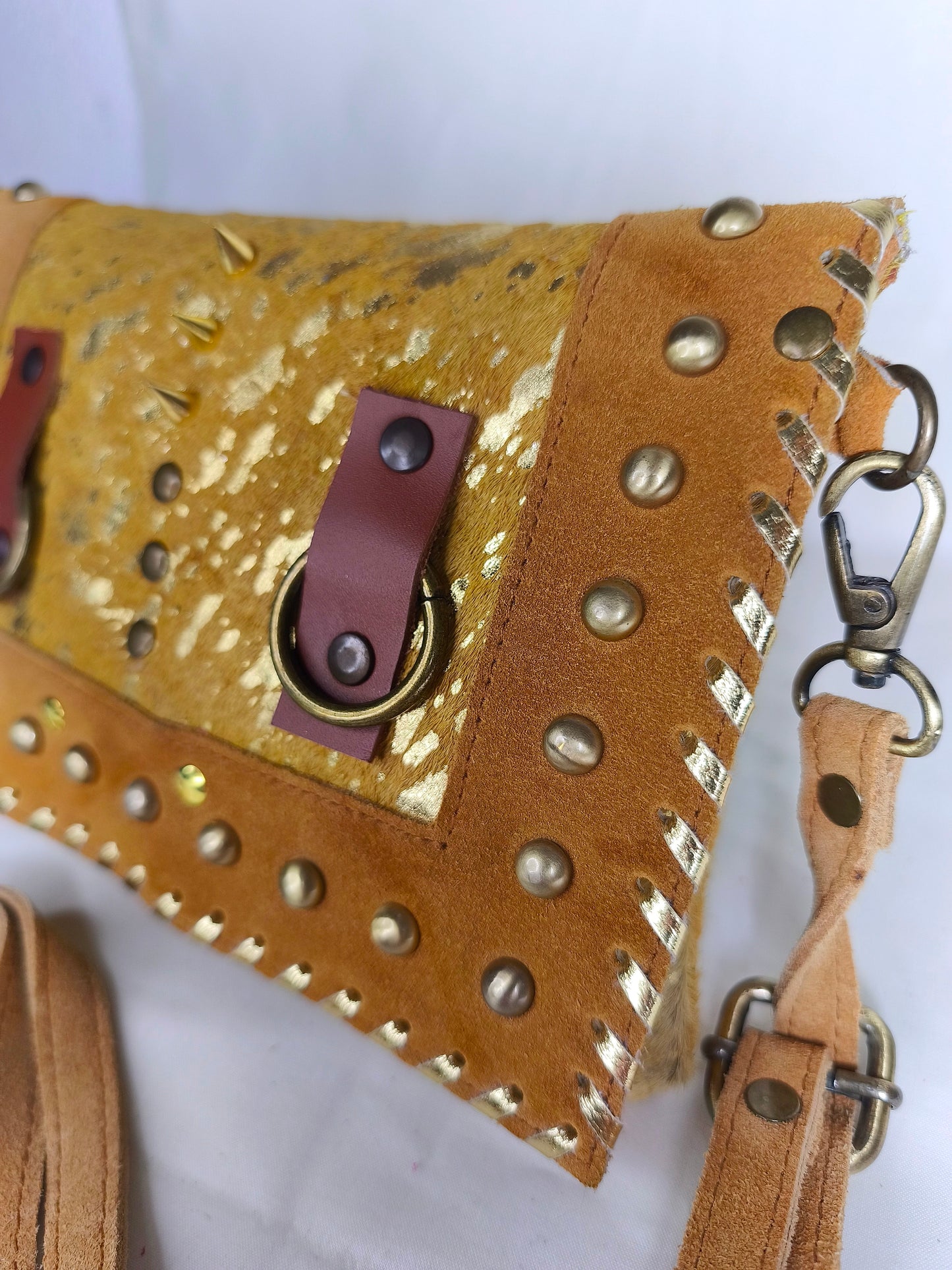 Bolso artesanal de cuero natural en tono mostaza con detalles dorados