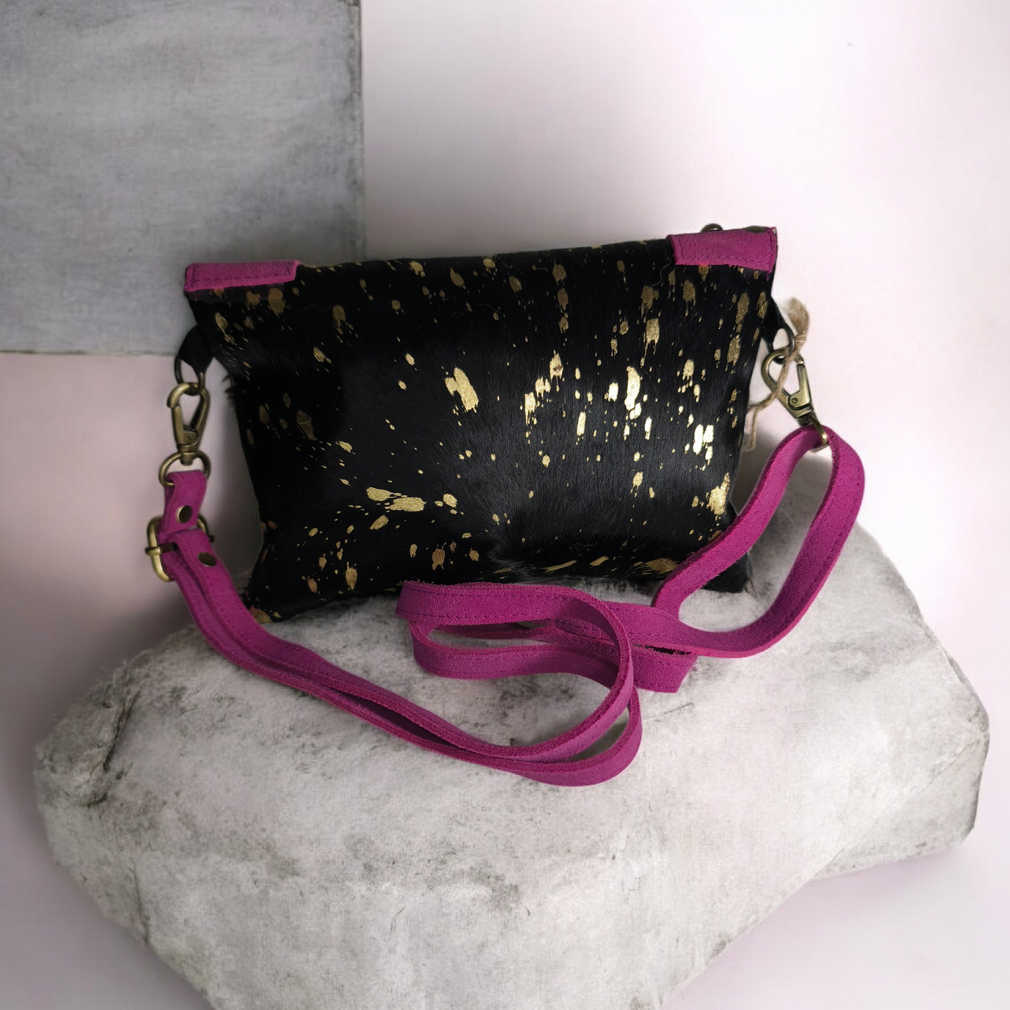 Bolso artesanal en piel con salpicaduras doradas y marco fucsia